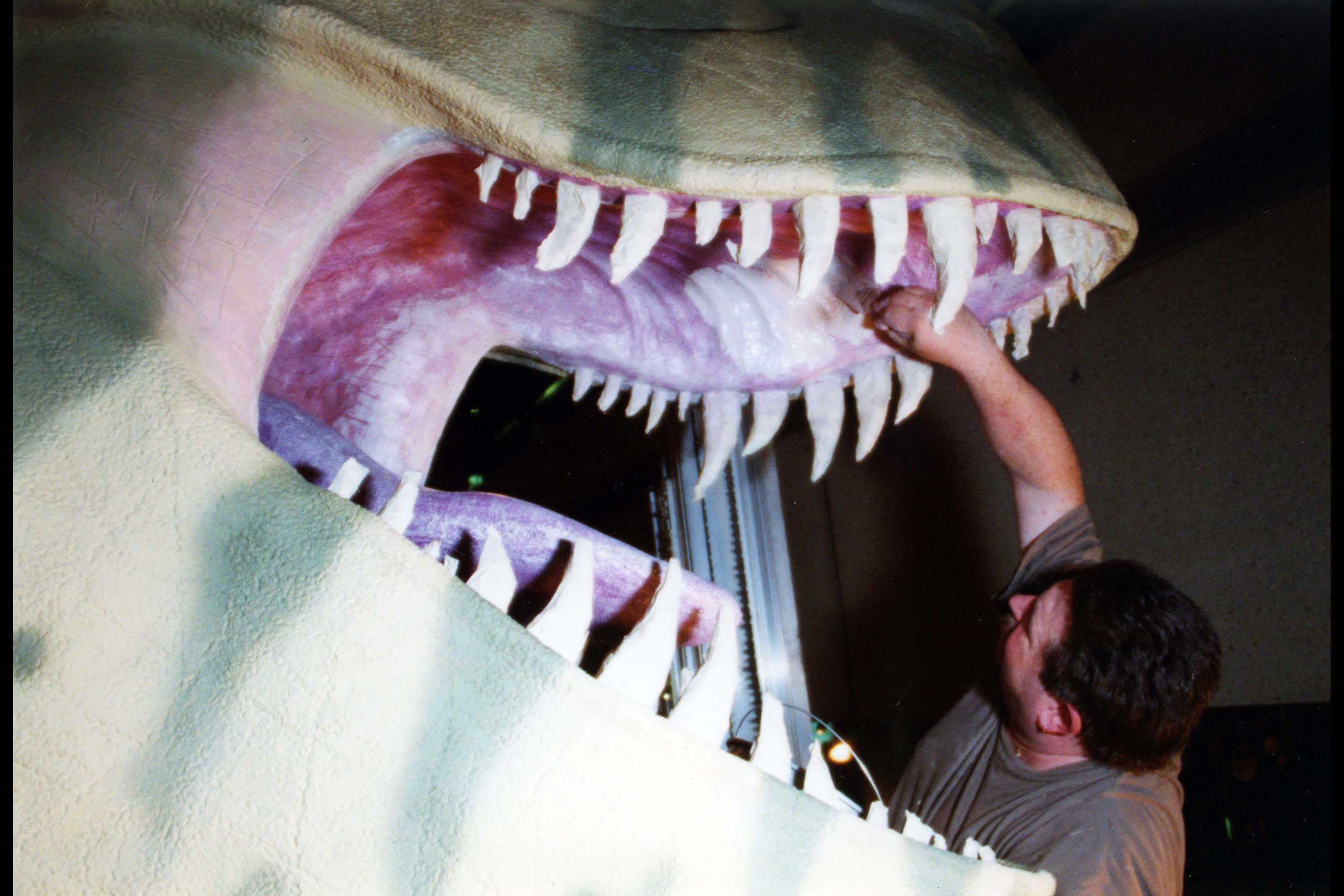 Current Model T.rex Teeth. This is a photograph of someone painting the teeth and mouth of the model T. Rex.